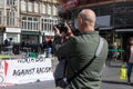 Man taking a photograph with a camera t anti-racism and black lives matters protest rally demonstration with banners and posters