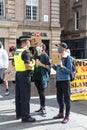 Police officer speaking to protesters with homemade placards at Anti-racism and black lives matters protest rally demonstration