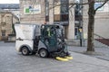 Road street sweeping vehicle with brushes on the road being driven to clean urban environment