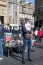 Young adult male holding copies of Socialist Worker