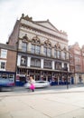 Newcastle Tyne Theatre building exterior with traffic moving past