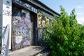 Graffiti on an old derelict closed down building and door in vibrant colourful spray paint colours. Background, urban retro