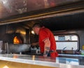 A man bakes pizzas in a rennovated classic van used as a portable canteen serving pizza at Gateshead, Newcastle