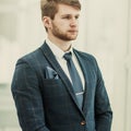 Newcomer businessman in a business suit stands near the window Royalty Free Stock Photo