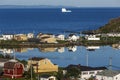 Newfoundland coastal town with distant iceberg Royalty Free Stock Photo