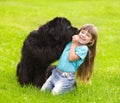 Newfoundland dog kisses a girl Royalty Free Stock Photo