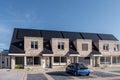 Newly build houses with solar panels attached on the roof against a sunny sky Close up of new building with black solar Royalty Free Stock Photo