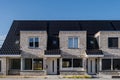 Newly build houses with solar panels attached on the roof against a sunny sky Close up of new building with black solar Royalty Free Stock Photo