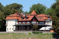 Newly built castle looking mostly wooden local hotel built in traditional style with large front porch surrounded with dense