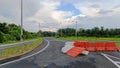 The newly constructed road, which is still not fully open to the public, is indicated by plastic roadblocks blocking the path. Royalty Free Stock Photo
