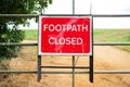 Newly erected Footpath Closed sign seen attached to a fence at a public footpath area.