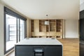 A newly fitted modern kitchen with an island with a wine fridge and views into a sitting room with an oak bookcase Royalty Free Stock Photo