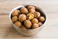 Newly harvested walnuts, designed in stainless steel bowl on a wooden table Royalty Free Stock Photo