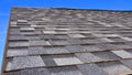 Newly Installed Roof with Textured Asphalt Shingles or Bitumen Tiles on the Rooftop Exterior.