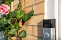 Newly installed wireless smart doorbell system seen installed on a doorway wooden frame.