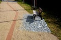 Newly introduced park beige gravel walkways, metal rusty corten steel design strips in the road surface. benches on a square stone Royalty Free Stock Photo