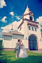 Newly married kissing on a background of the church field instagram stile