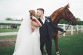 Newly married wedding couple stand with beautiful horse on nature Royalty Free Stock Photo