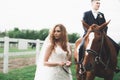 Newly married wedding couple stand with beautiful horse on nature Royalty Free Stock Photo