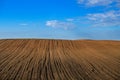 Newly ploughed agricultural field under cloudy blue sky Royalty Free Stock Photo