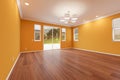 Newly Remodeled Room of House with Finished Wood Floors, Moulding, Yellow Ochre Paint and Ceiling Lights