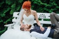 Newly wed couple on a bench together in the midst of a juniper forrest in a park