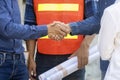 Newly wed couple is handshaking with engineering contractor at their under construction house to inspect building progress and Royalty Free Stock Photo