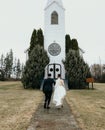 Newly weds running in front of old church holding hands Royalty Free Stock Photo