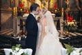 Newlywed bride and groom first kiss at wedding ceremony in church Royalty Free Stock Photo