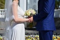 The newlywed couple is holding a beautiful wedding bouquet. Classical wedding photography, symbolizing unity, love and the creati