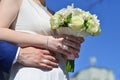 The newlywed couple is holding a beautiful wedding bouquet. Classical wedding photography, symbolizing unity, love and the creati