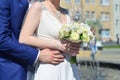 The newlywed couple is holding a beautiful wedding bouquet. Classical wedding photography, symbolizing unity, love and the creati