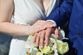 The newlywed couple is holding a beautiful wedding bouquet. Classical wedding photography, symbolizing unity, love and the creati