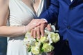 The newlywed couple is holding a beautiful wedding bouquet. Classical wedding photography, symbolizing unity, love and the creati