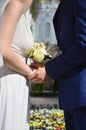 The newlywed couple is holding a beautiful wedding bouquet. Classical wedding photography, symbolizing unity, love and the creati