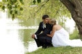 Newlywed couple kissing by lake Royalty Free Stock Photo