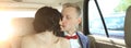 Newlywed couple kissing in wedding car limousine. Royalty Free Stock Photo