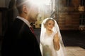 Newlywed couple standing in street, Beautiful blonde bride in white wedding dress posing near handsome groom in sunny french