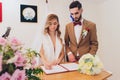 Newlyweds append signatures in a registry office during wedding registration.