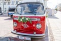 Newlyweds car. Red minibus volkswagen. Retro bus car. Decorated with bouquets of flowers. Festive decor, bridal bouquet