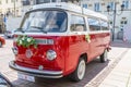 Newlyweds car. Red minibus volkswagen. Retro bus car. Decorated with bouquets of flowers. Festive decor, bridal bouquet