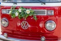 Newlyweds car. Red minibus volkswagen. Retro bus car. Decorated with bouquets of flowers. Festive decor, bridal bouquet