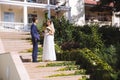 The newlyweds climb the steps to the wedding ceremony. The girl looks thoughtfully into the distance, she wears a light