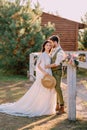 Newlyweds in cowboy style standing and hugging on ranch