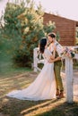 Newlyweds in cowboy style standing and hugging on ranch