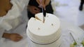 Detail of a couple's hands cutting a wedding cake. Newlyweds cutting the wedding cake, top view. The bride and groom Royalty Free Stock Photo