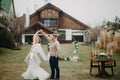 Newlyweds dance near banquet table and wedding arch