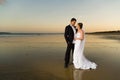 Newlyweds on a deserted beach at sunset Royalty Free Stock Photo