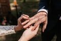 Newlyweds exchange rings against the backdrop of greenery