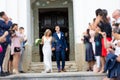 Newlyweds exiting the church after the wedding ceremony, family and friends celebrating their love with the shower of Royalty Free Stock Photo